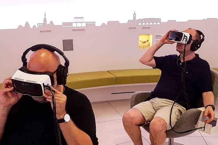 Zwei Männer mit Augmented Reality Brille in einem Touristinfo