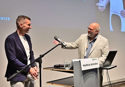 Moderator und Referent auf einer Bühne
