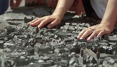 Zwei Hände berühren das Tastmodell der Innenstadt von Erfurt 